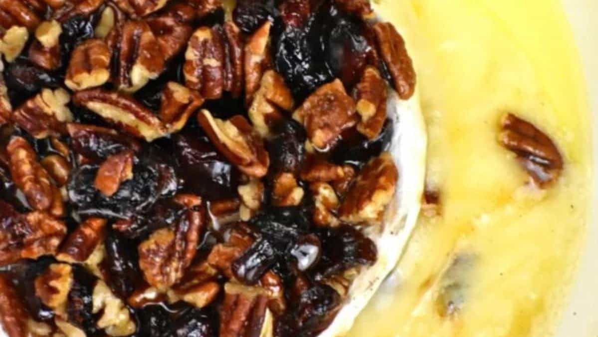 Wheel of brie cheese topped with cranberries and pecans.