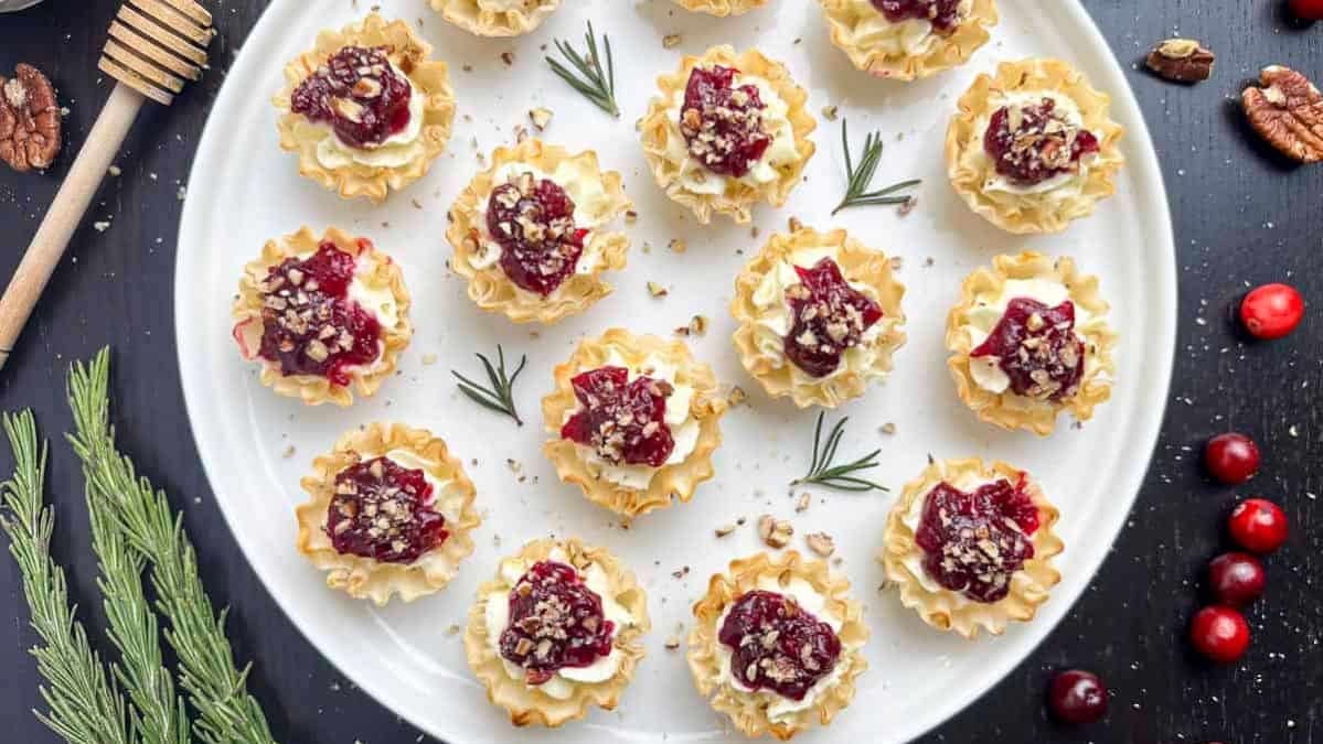 Cranberry tartlets on a round tray garnished with refreshers.